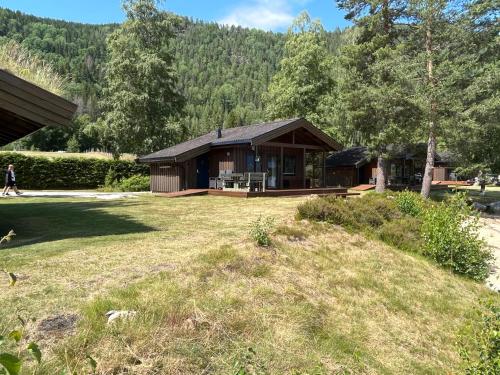 a house in the middle of a yard at Nisser Hyttegrend og Camping in Fjone