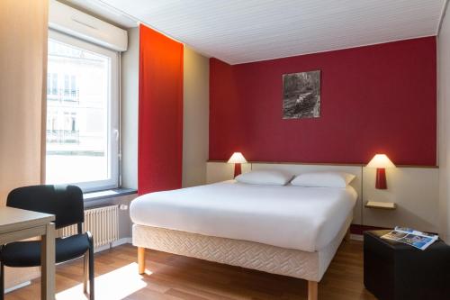 a bedroom with a white bed and a red wall at The Originals Access, Hôtel Arum, Remiremont (Inter-Hotel) in Remiremont