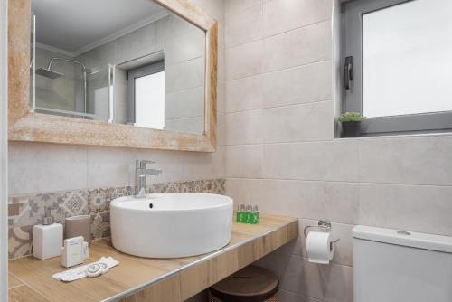 y baño con lavabo y espejo. en Varkiza Seaside Apartment, en Vari