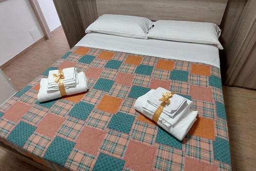 a bed with two white towels and bows on it at Casa MiDa, vista panoramica sulla Maiella in Castelfrentano