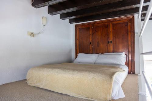 - un lit avec une tête de lit en bois dans l'établissement Loft/Attic, Sea Views, Private Terrace, à Cadix