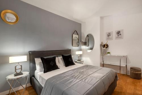 a bedroom with a large bed with two tables and a mirror at Cardilli Trastevere in Rome