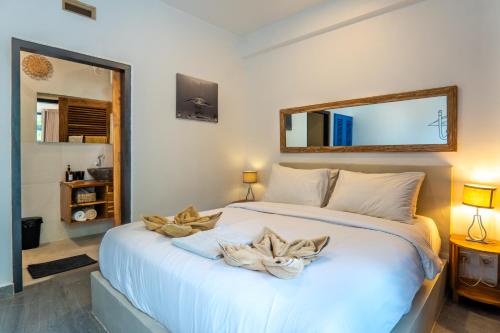 1 dormitorio con 1 cama blanca grande y espejo en Dragon Dive Komodo Dive Resort, en Labuan Bajo
