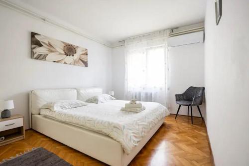a white bedroom with a white bed and a chair at Apartment Tomas,,,Spacious house with private parking,terrace,5G Internet,,,,, in Zadar