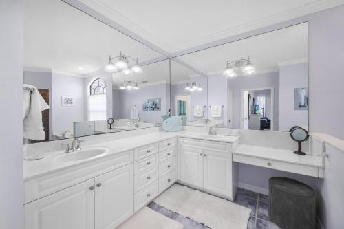 a white bathroom with two sinks and a large mirror at 951 Ruby Court in Marco Island