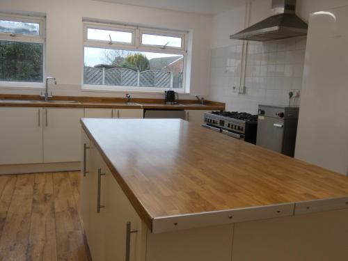 a large kitchen with a wooden counter top in it at Very Spacious 9 Bedroom House-Garden-Parking for 6 in Gloucester
