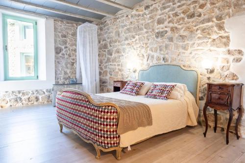a bedroom with a bed and a stone wall at Posada Rolisas in Polanco