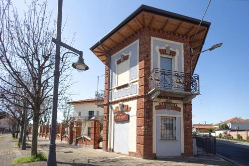 a small brick building with a balcony on a street at Le Fare in Fara Novarese
