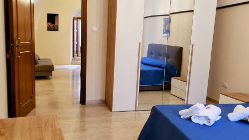 a bedroom with a blue bed and a mirror at Dimora Maggi al Caminetto - Affitti Brevi Italia in Monte SantʼAngelo