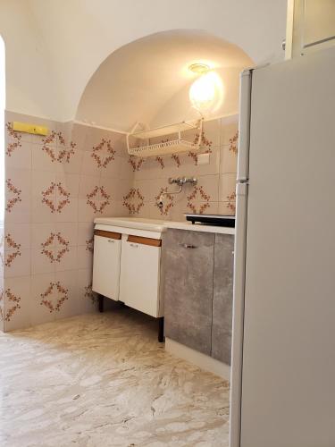 a kitchen with a refrigerator in a room at Dimora Maggi al Caminetto - Affitti Brevi Italia in Monte SantʼAngelo