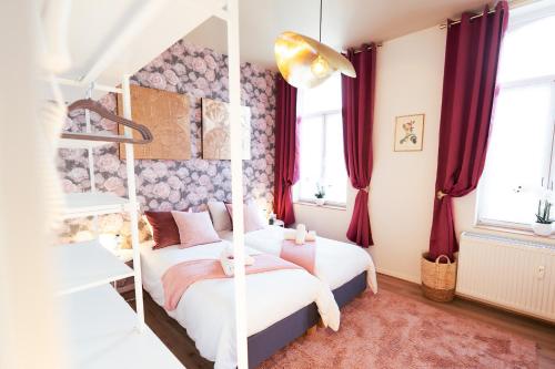 um quarto com 2 camas e cortinas vermelhas em Lets Relax - Coté jardin em Mons
