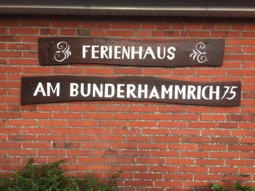 d'un mur en briques avec un panneau indiquant la rue. dans l'établissement Ferienhaus am Bunderhammrich 25184, à Bunde