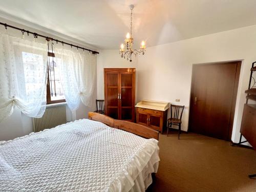 1 dormitorio con cama y escritorio. en Appartamento Molina, en Molina di Ledro