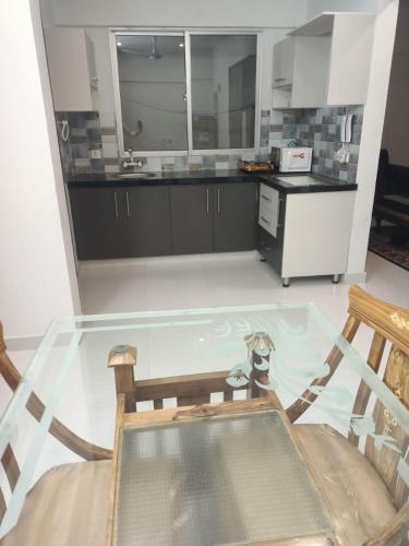 a kitchen with a glass table and a counter at SeaView Family Guest House Small Bukhari in Karachi