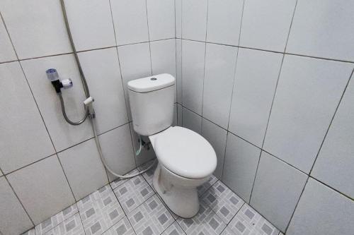 a bathroom with a white toilet in a stall at OYO 93867 Minso Inn Sepanjang in Yogyakarta