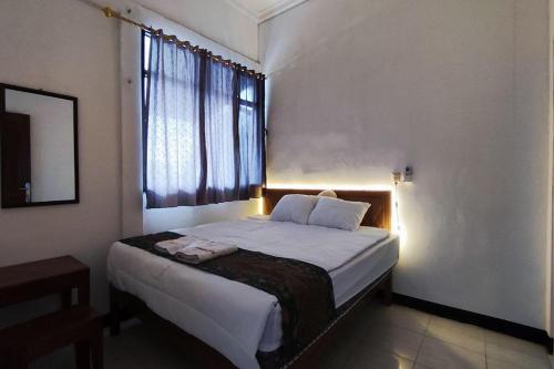 a bedroom with a large bed with a window at OYO 93867 Minso Inn Sepanjang in Yogyakarta