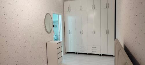 La salle de bains est pourvue de placards blancs et d'un miroir mural. dans l'établissement Сдам в аренду квартиру, à Taldykolʼ