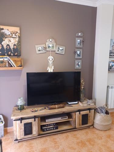 a flat screen tv sitting on top of a wooden entertainment center at La casa del gatico in Lumbier