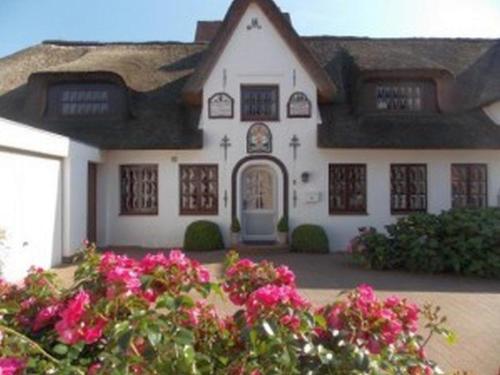 a house with pink flowers in front of it at Hansen Nieblum Haushälfte in Nieblum