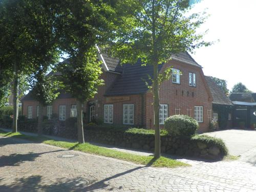 a red brick house with trees in front of it at Nordseestübchen Whg 05 in Nieblum