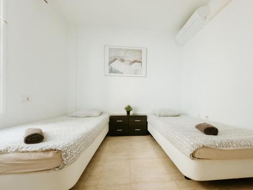 2 camas en una habitación con paredes blancas en Spacious 2 BR Golden Apartment by Aqua Vista Tenerife, en Callao Salvaje
