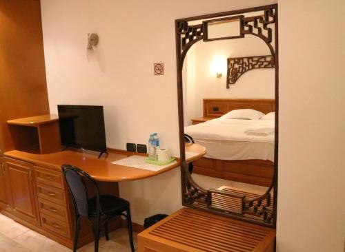 um quarto com uma secretária com um espelho e uma cama em Max Residence em Pattaya Central