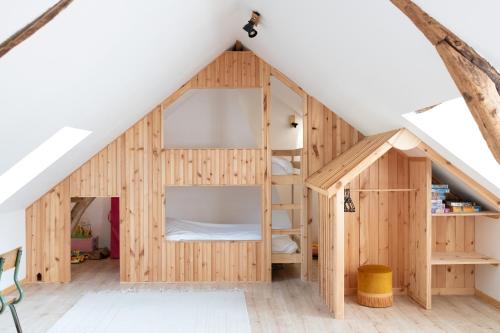 a wooden play house with a bunk bed in the attic at Les Frangines - maison de ville avec jardin Ault in Ault