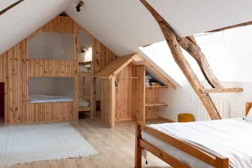 une chambre avec des armoires en bois et un lit dans un grenier dans l'établissement Les Frangines - maison de ville avec jardin Ault, à Ault