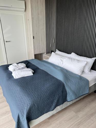 um quarto com uma cama grande e toalhas em Wave Baltic Central View em Międzyzdroje