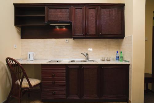 a kitchen with a sink and wooden cabinets at Pensjonat Lorien in Szczawno-Zdrój