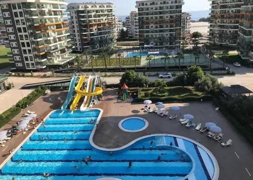 a swimming pool with blue stairs in a city at Siberland olive garden 1+1 residence spa - pool in Alanya