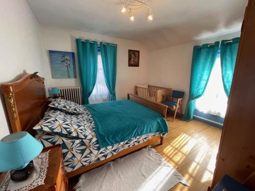 - une chambre avec des rideaux bleus, un lit et une chaise dans l'établissement Les Jardins de Jacinthe, à Sarlat-la-Canéda