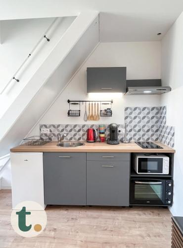 une cuisine avec un évier et une cuisinière dans l'établissement Tranquiloue - Idéal Duplex T2 - 8min du Puy du Fou, à La Verrie