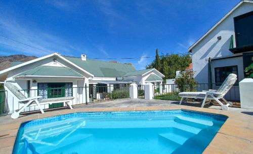 a swimming pool in front of a house at Koo Karoo Guest Lodge and Self Catering in Montagu