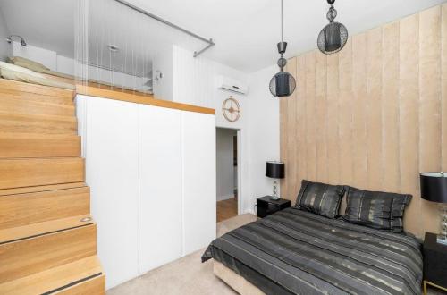 1 dormitorio con cama y pared blanca en Apartament Chmielna Park, en Gdansk