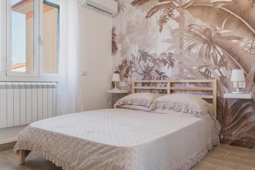 a bedroom with a bed with a tropical wallpaper at Enjoy and Fly in Fiumicino