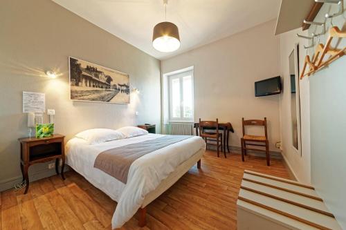 1 dormitorio con 1 cama, mesa y sillas en Contact Hôtel du Commerce et son restaurant Côte à Côte, en Autun