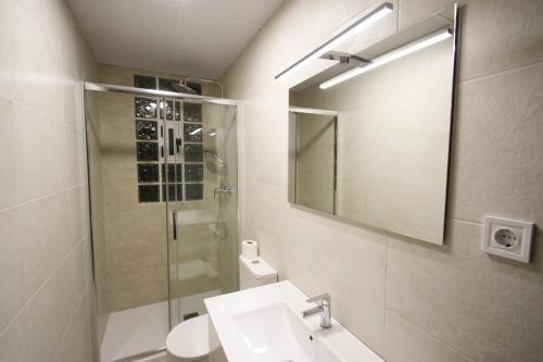 y baño con lavabo, ducha y espejo. en Villa Lyna, en Miami Platja
