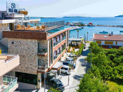 un edificio con coches estacionados frente a un puerto deportivo en Si Urla Hotel, en Urla