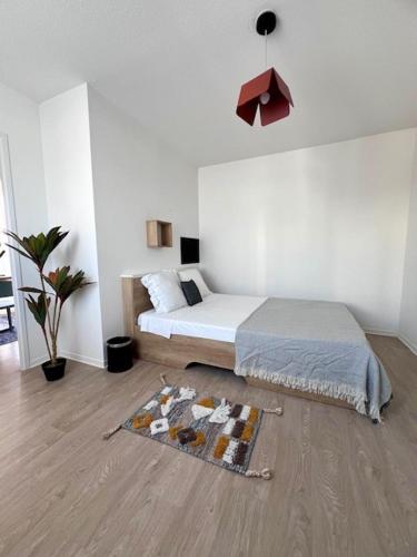 une chambre avec un lit et un tapis au sol dans l'établissement UXCO Le Spot, à La Rochelle