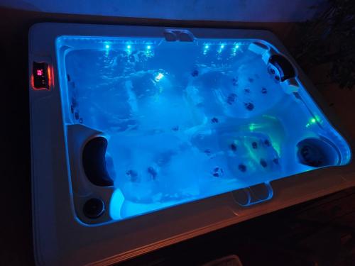 a hot tub with blue lights in a room at Maison 3 étoiles à 50m mer plages îles nature piscine chauffée jacuzzi privé WIFI in Le Port-des-Barques