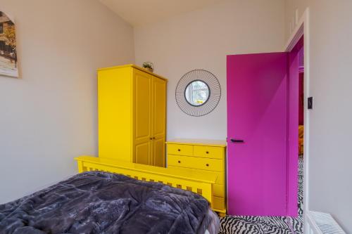 ein Schlafzimmer mit einem gelben und rosa Schrank und einem Bett in der Unterkunft Ashvale Stay - SJA Stays - Unique 1 Bed Apartment in Aberdeen