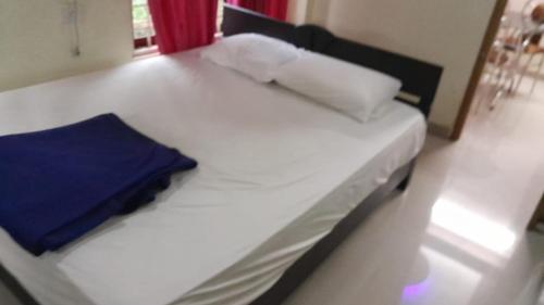 a bedroom with a white bed with a blue pillow at SNOWVALLEY RESIDENCY Vagamon in Vagamon