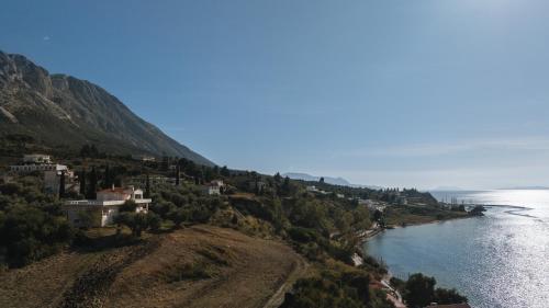 a town on a hill next to a body of water at Luzazul 2 bed apartment with jacuzzi and sea view in Paleros