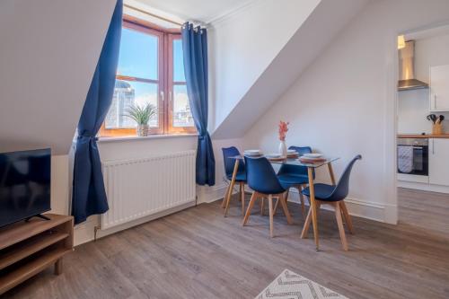 uma sala de jantar com cadeiras azuis e uma mesa em Summerfield Stay - SJA Stays - Modern 1 Bed Apartment em Aberdeen