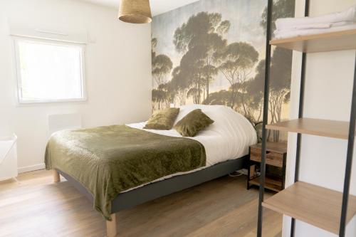 1 dormitorio con 1 cama con una pintura en la pared en La Vie En Gîte (La Taïga), en Sainte-Florence