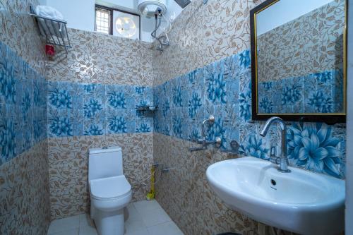 ein Badezimmer mit einem Waschbecken, einem WC und einem Spiegel in der Unterkunft Jaavi Homestay Nainital in Nainital