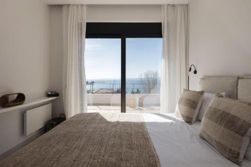 a bedroom with a bed and a large window at Luzazul 2 bed apartment with jacuzzi and sea view in Paleros