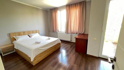 a small bedroom with a bed and two windows at Garden House Tbilisi in Tbilisi City
