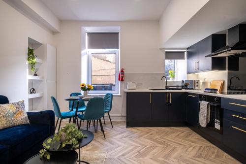 a kitchen and living room with a couch and a table at Willowstay - SJA Stays - Modern 2 Bed Apartment in Aberdeen